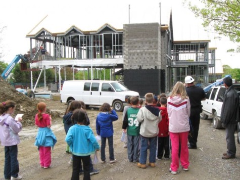 Police Officer Lloyd Burke (second from right, with hard hat) surveys the progress at his future workplace, the Watertown police station, in May 2009. 