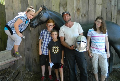 Stuntman Joe Darrigo (in white shirt) poses with reporters from the Cunniff Kids News on the grounds of King Richards Faire on Aug. 26, 2014, during his preparation for the opening of the Renaissance fairs 33d season in Carver, Mass.
