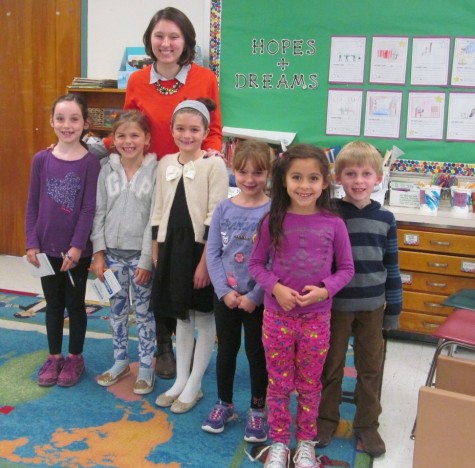 Reporters from the Cunniff Kids News pose with new second-grade teacher Olivia Cifrino (third from left) at Cunniff Elementary School in Watertown, Mass.