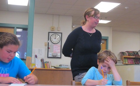 New Cunniff art teacher Jaclyn Meyer walks behind Cunniff Kids News reporters during an interview in the newsroom Oct. 6, 2015.