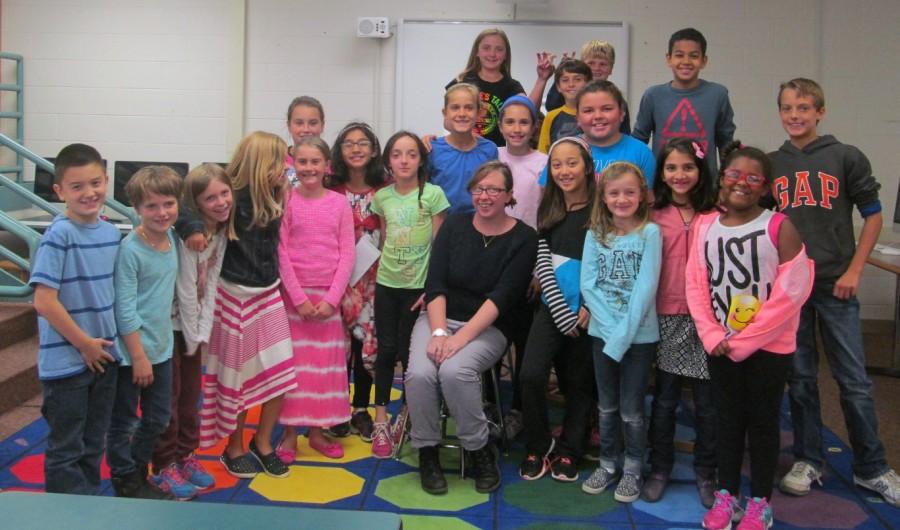 Jaclyn Meyer (sitting, center), the new art teacher at Cunniff Elementary in Watertown, Mass., poses some of the staff of the Cunniff Kids News after an interview in the newsroom Oct. 6, 2015. 