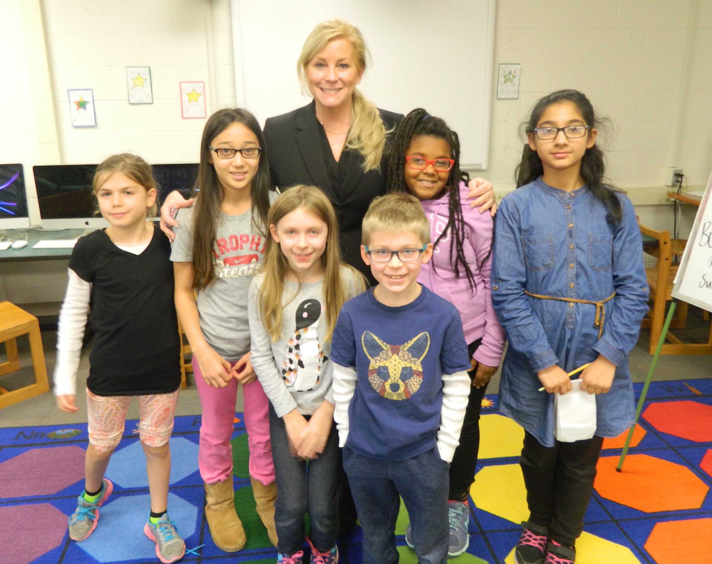 Theresa McGuinness (center), assistant superintendent of Watertown schools, poses with reporters from the Cunniff Kids News after an interview in the CKN newsroom on Dec. 7, 2016.