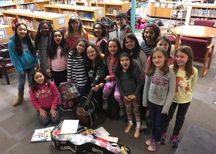 Singer Allie Moss (with guitar) poses with Cunniff Kids News reporters after an interview in their newsroom at Cunniff Elementary School in Watertown, Mass., on March 21, 2017.