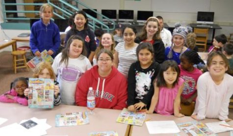 Cunniff parent Maura Gallagher (front row in Red Sox sweatshirt) poses with reporters in the newsroom of the Cunniff Kids News
while promoting the Nov. 26-30 Scholastic Book Fair in the cafetorium.