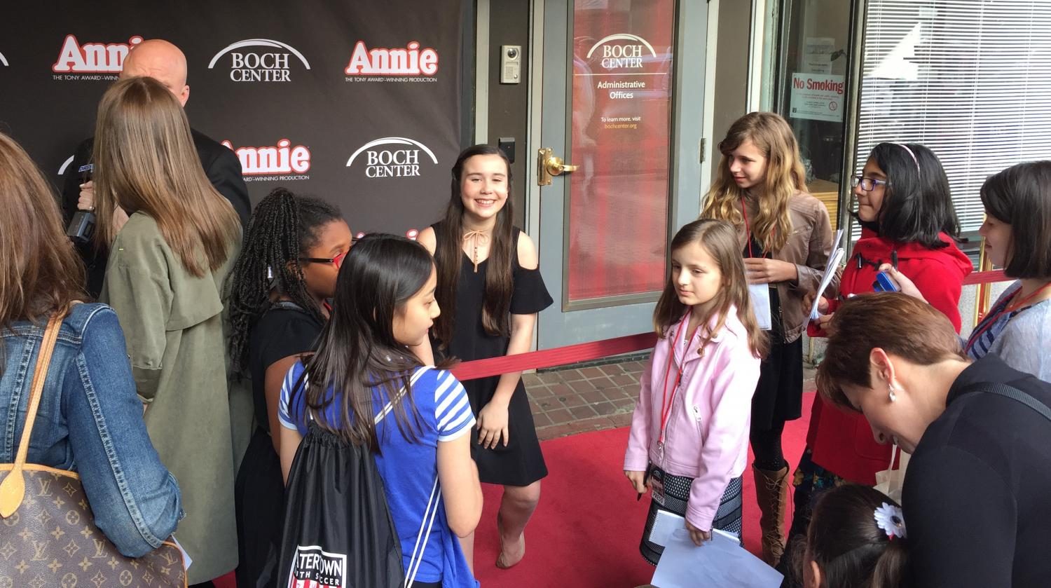 Angelina Carballo, who plays the lead in Annie during the current Boston run, talks with student reporters on the red carpet outside the Wang Theatre on May 10, 2017.