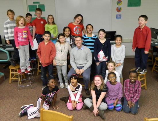 New fifth-grade teacher Lucas Donohue (seated in center) poses with the Cunniff Kids News staff after his interview in the newsroom. 