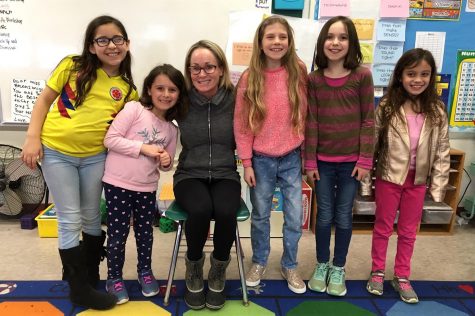 Watertown School Committee member Amy Donohue (third from left) poses with some student reporters from the Cunniff Kids News after an interview about the 2019 Watertown Spelling Bee.